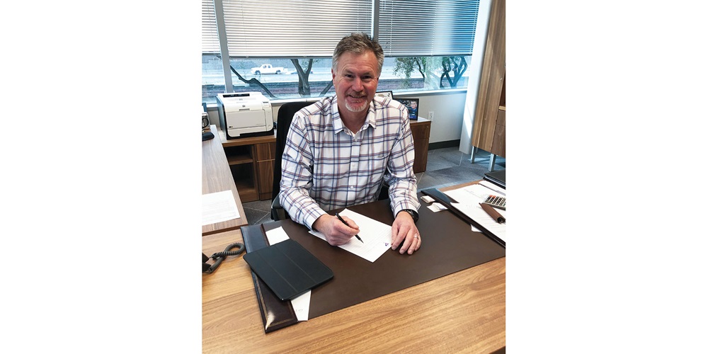NECA President Larry Beltramo sits at his desk