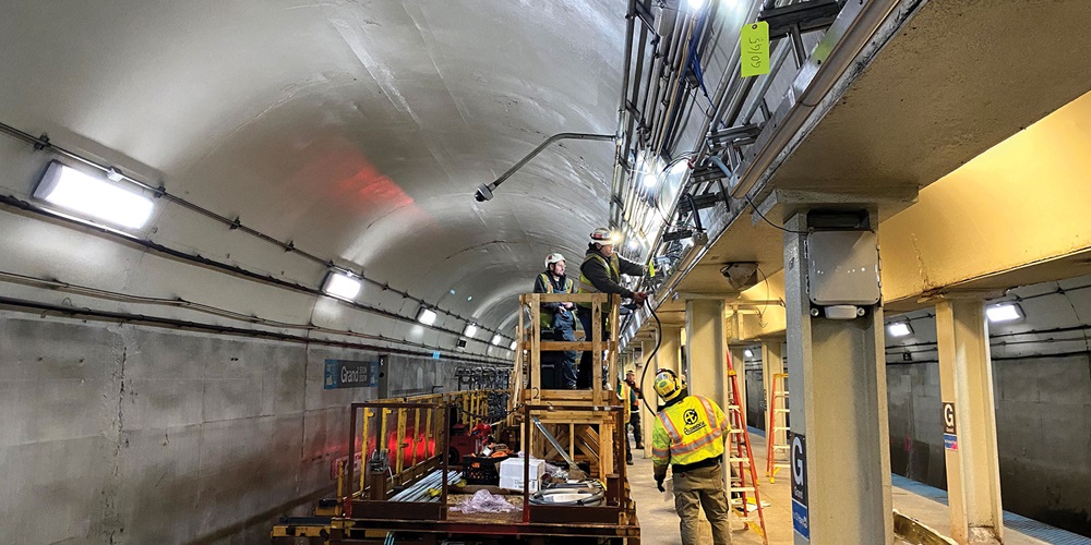 An electrical worker in safety gear stands on a subway platform under renovation | Aldridge Electric