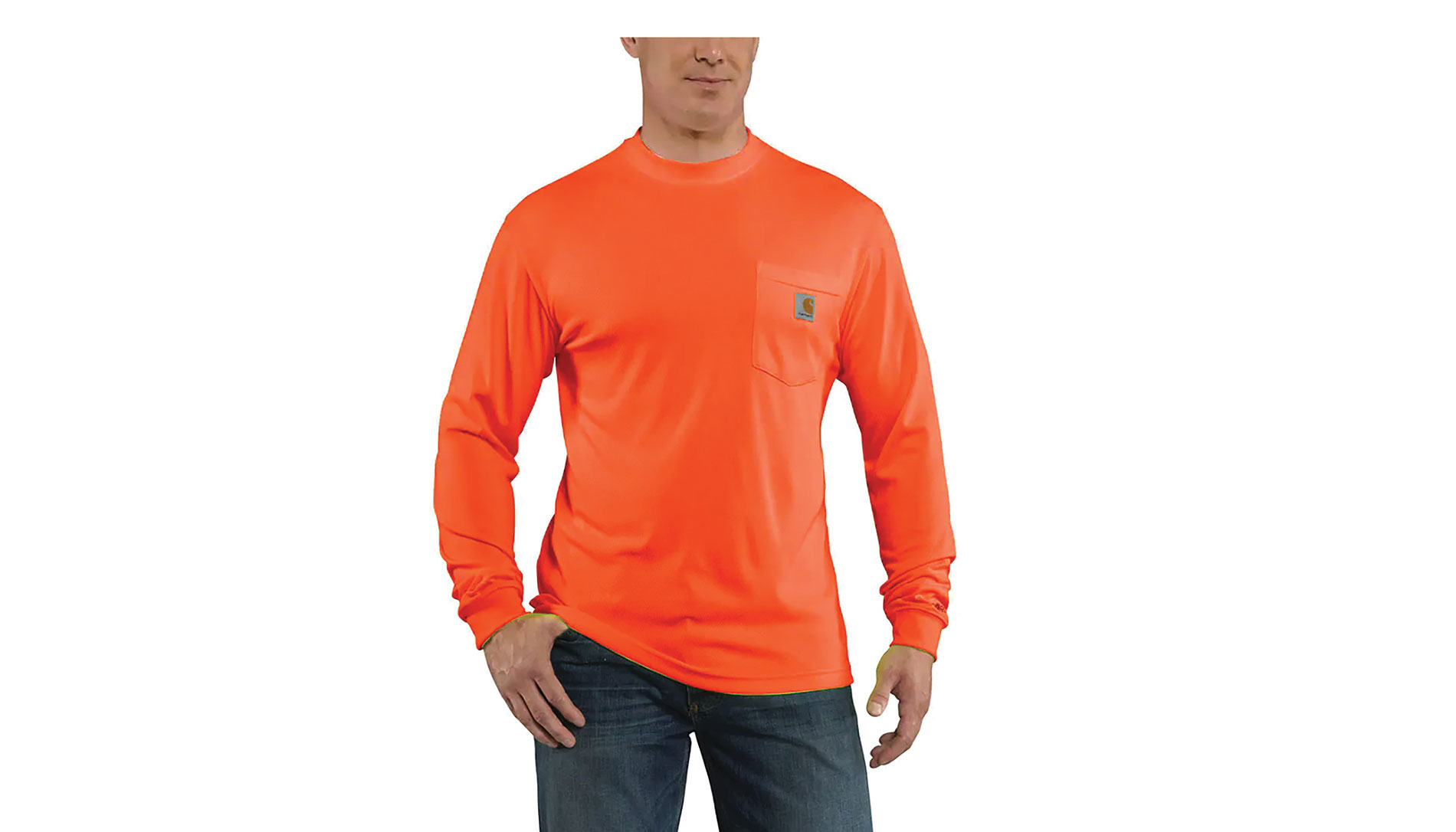 A man wears jeans and an orange shirt with the Carhartt logo. Image by Carhartt.