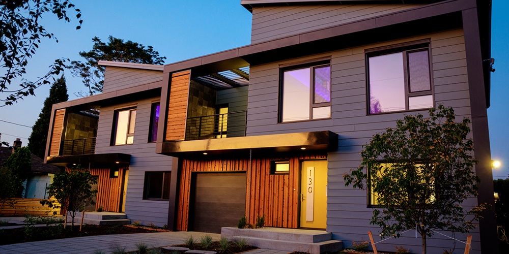 Modern duplex (two-family) dwelling built to passive house standards with energy-efficient windows and airtight design features.