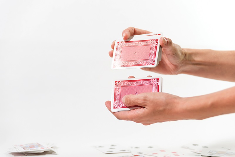 A pair of hands shuffles a deck of cards, representing shuffling of the deck that is happening in preparation for the 2029 NEC code changes