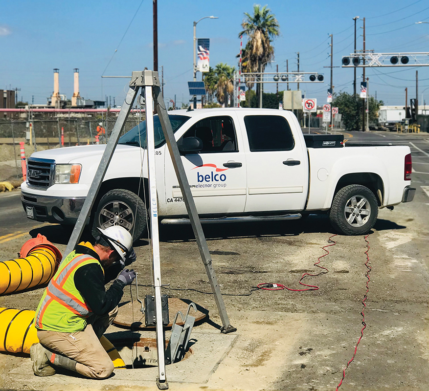 Elecnor Belco crew members investigate a maintenance hole as part of underground utility work. Photo by Elecnor Belco Electric Inc.