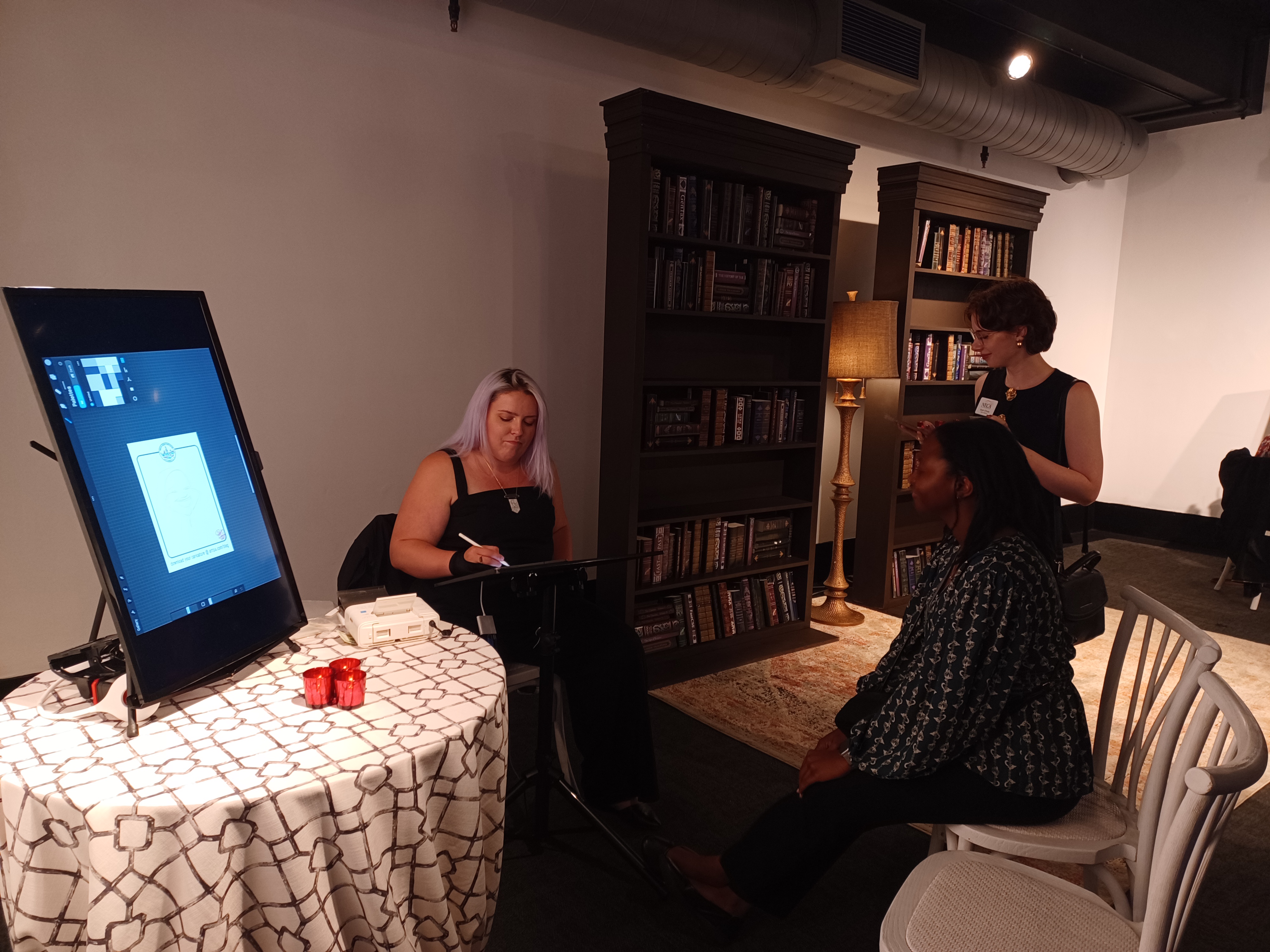 NECA staff member Mia Flowers gets her caricature drawn by a digital artist. 