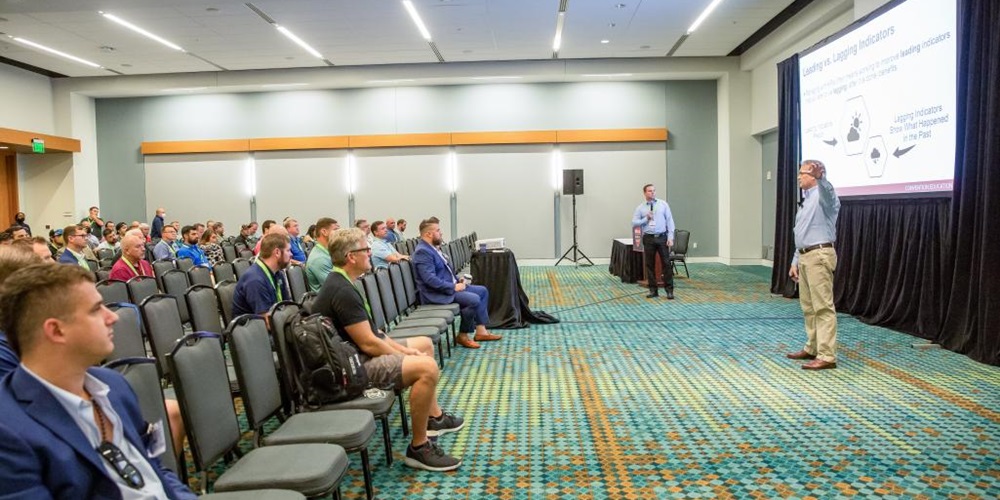 A man stands in front of a screen giving a presentation