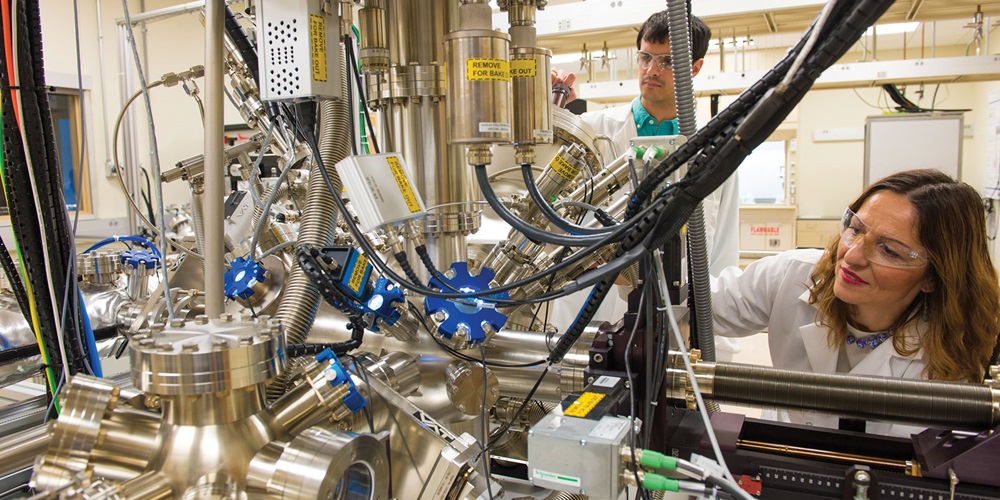 Researchers in a laboratory with a metal system and tubes. Image by Shutterstock / Snaidier / Argonne National Laboratory.