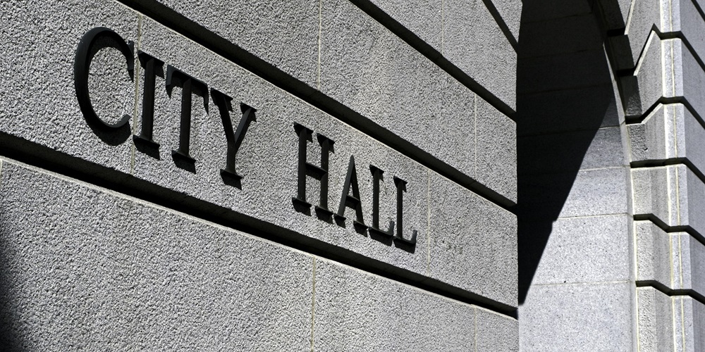 Close up of a building entrance with "City Hall" printed on it