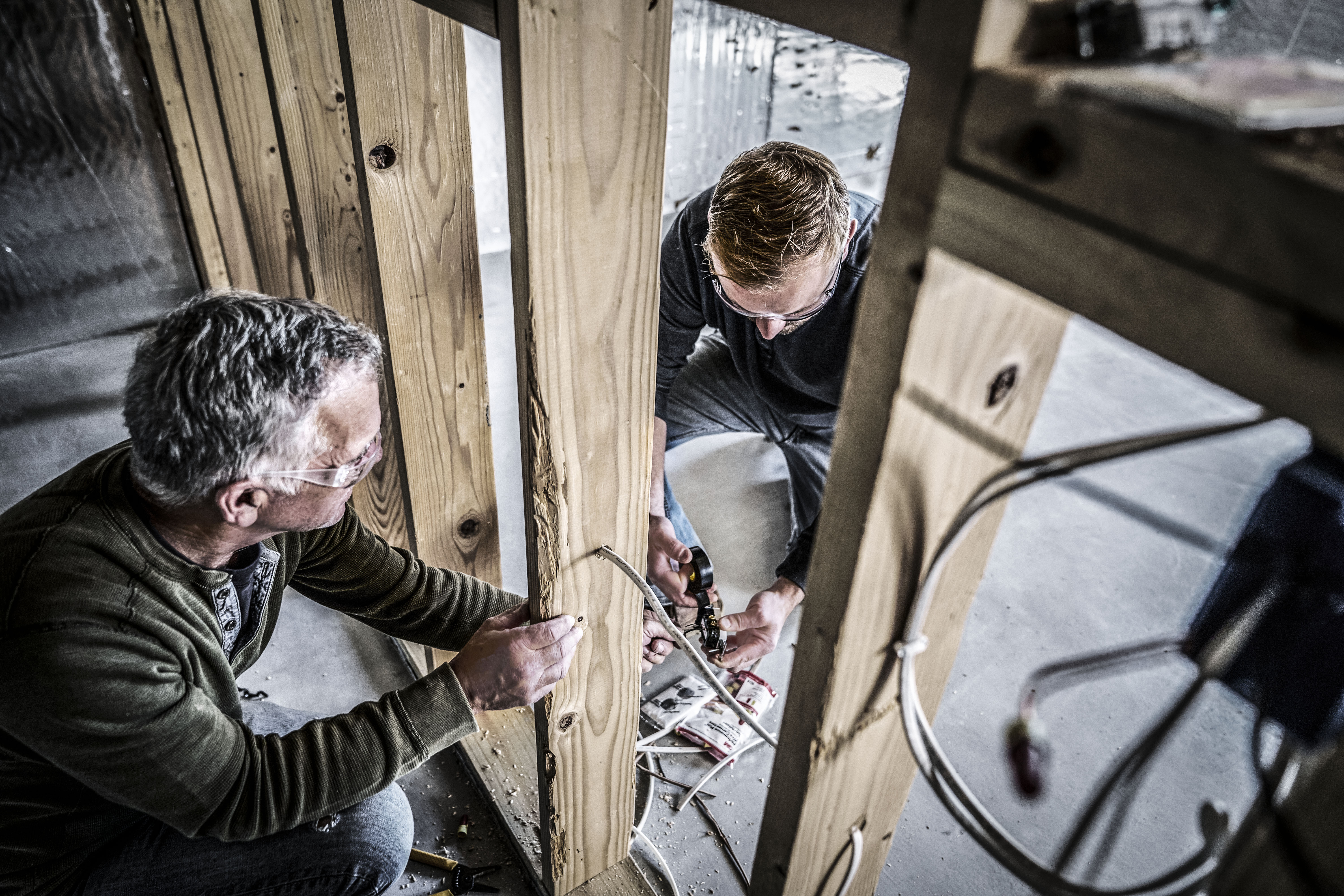 Two electricians work on wiring on a job site. | 3M