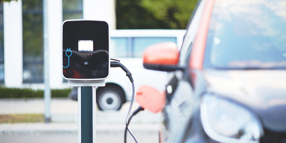 An electric vehicle plugged in to a digital charging station