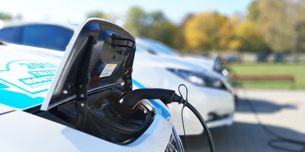 An electric vehicle plugged in to a charging station / EV charging / Electric vehicle charging equipment / electric vehicle infrastructure / EV charging infrastructure