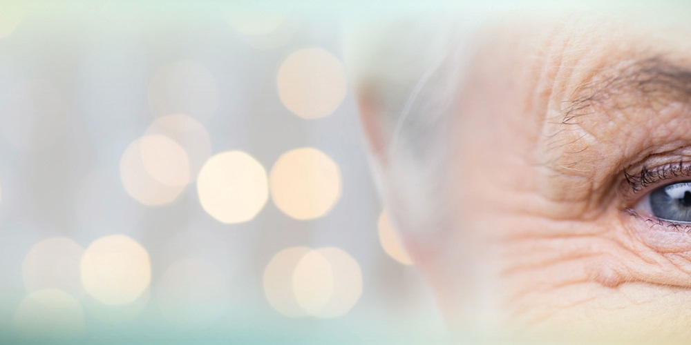 View of a partial face of an older person, focused on the eyes, with bokeh effects in the background