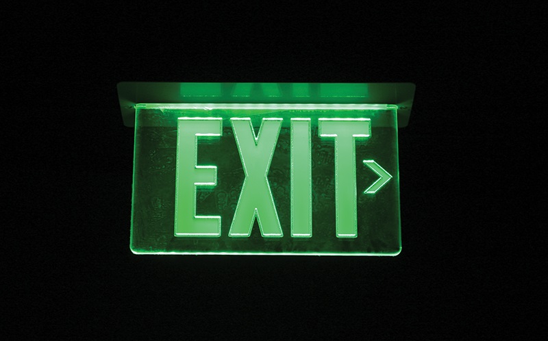 green exit sign against black backgrounf