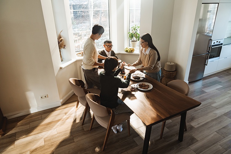 people sitting around a table in front of a window