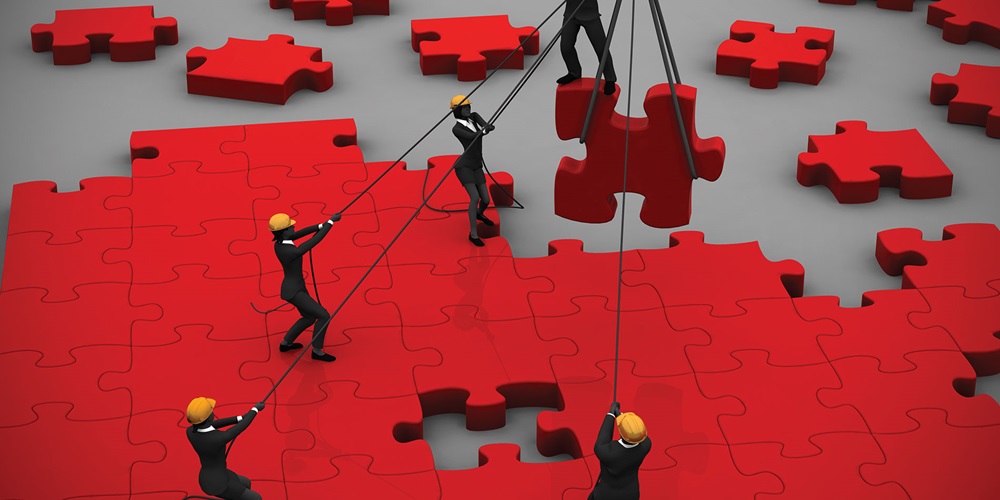 Construction workers move puzzle pieces into place | iStock / XPoint