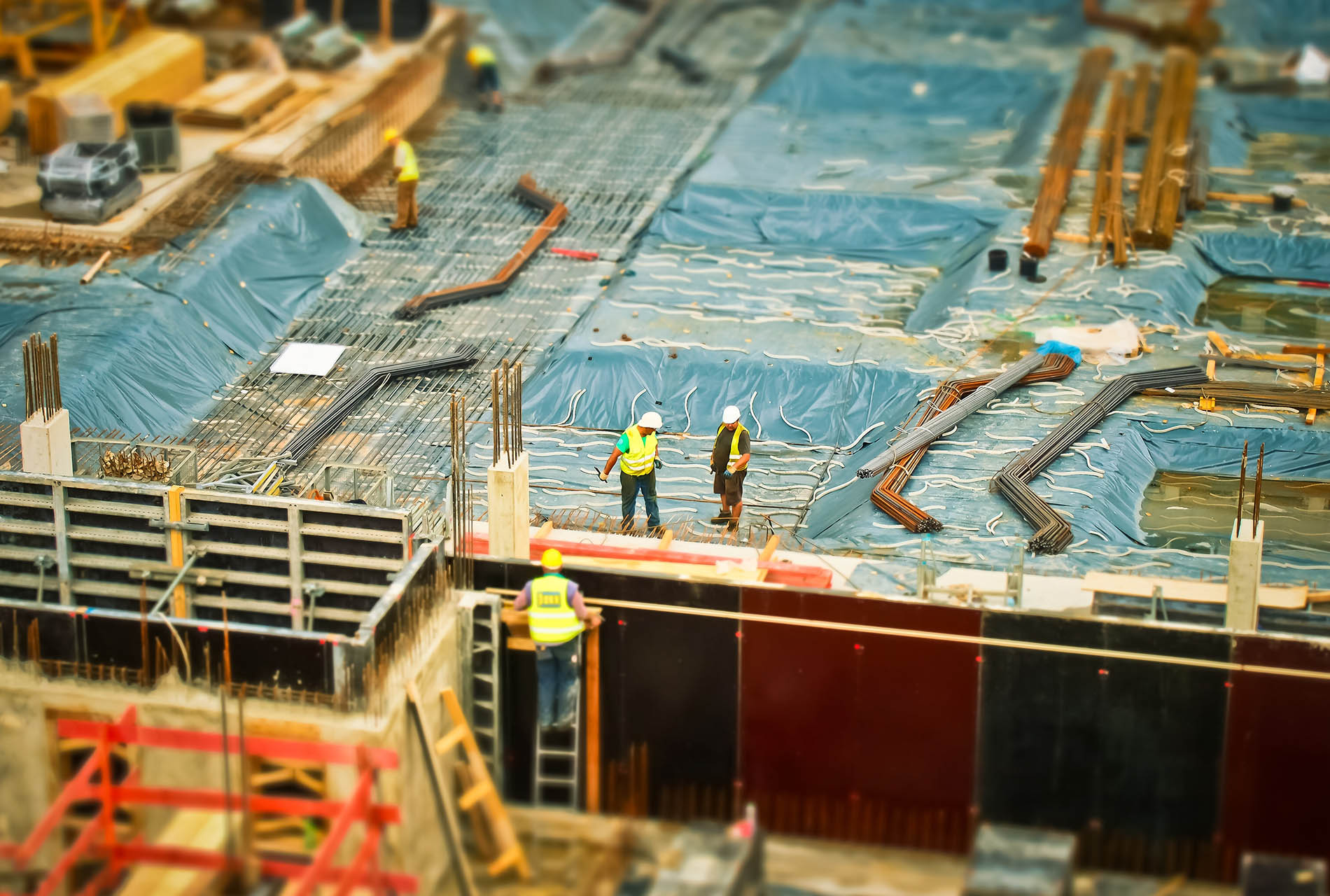 man-in-yellow-safety-vest-climbing-on-ladder-159358.jpg Men working at construction site.