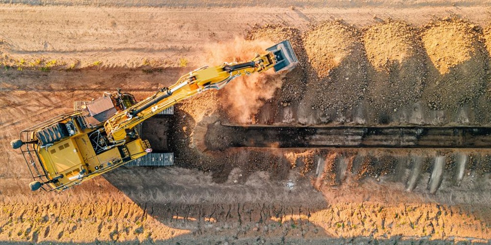 Aerial photo of a bulldozer digging in the dirt. Image by Built Robotics / Unsplash.