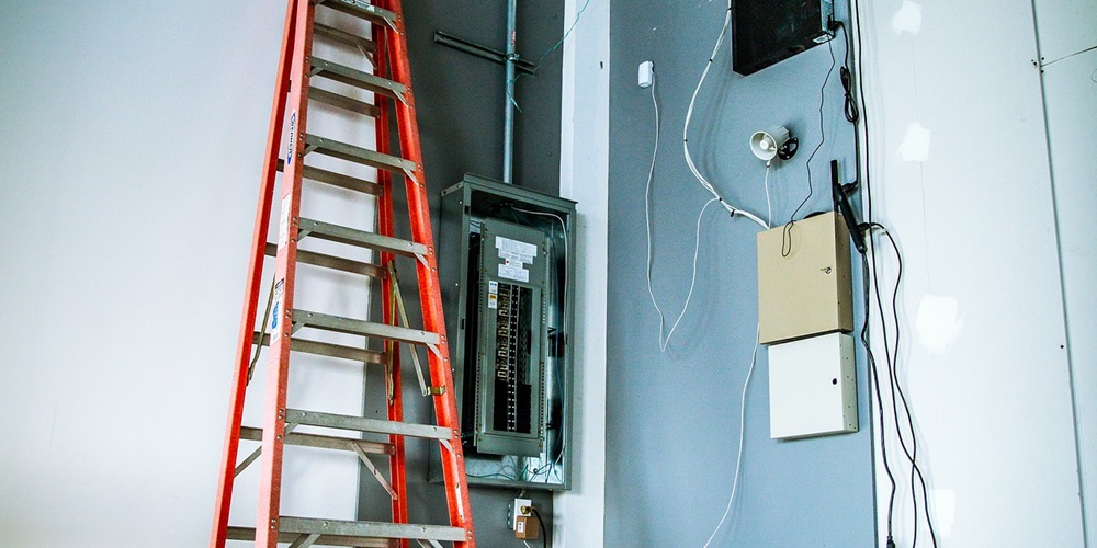 A ladder stands next to an electrical box