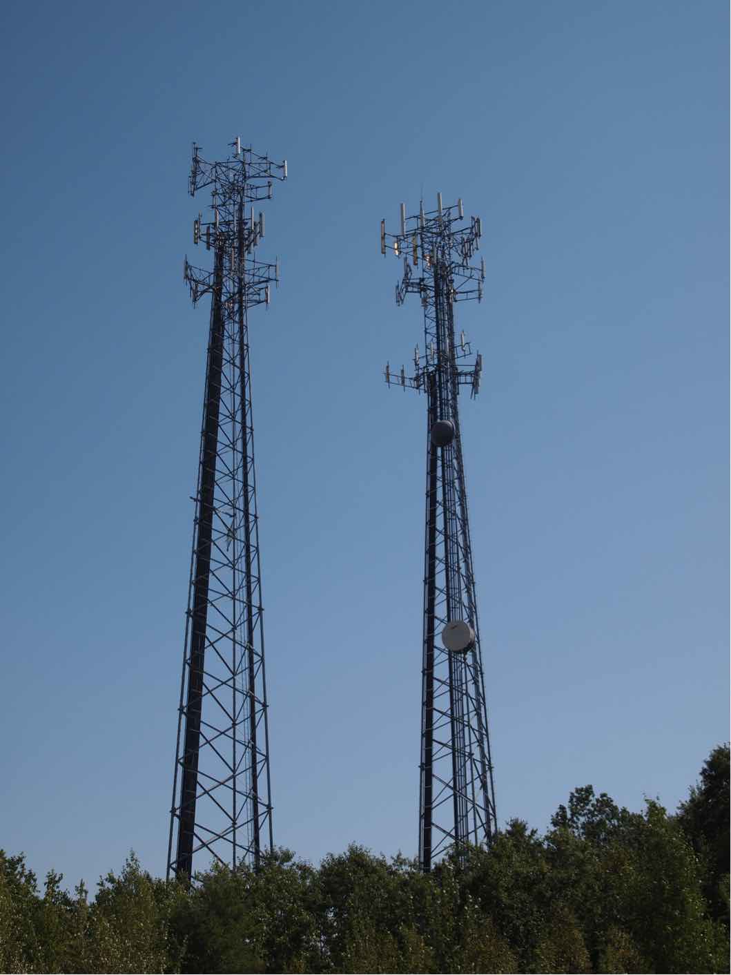 Cell towers with dozens of antennas and large bundles of coax cables up to the antennas. Photo by Jim Hayes.