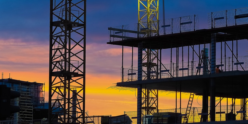 A construction site in sillouette against a sunset