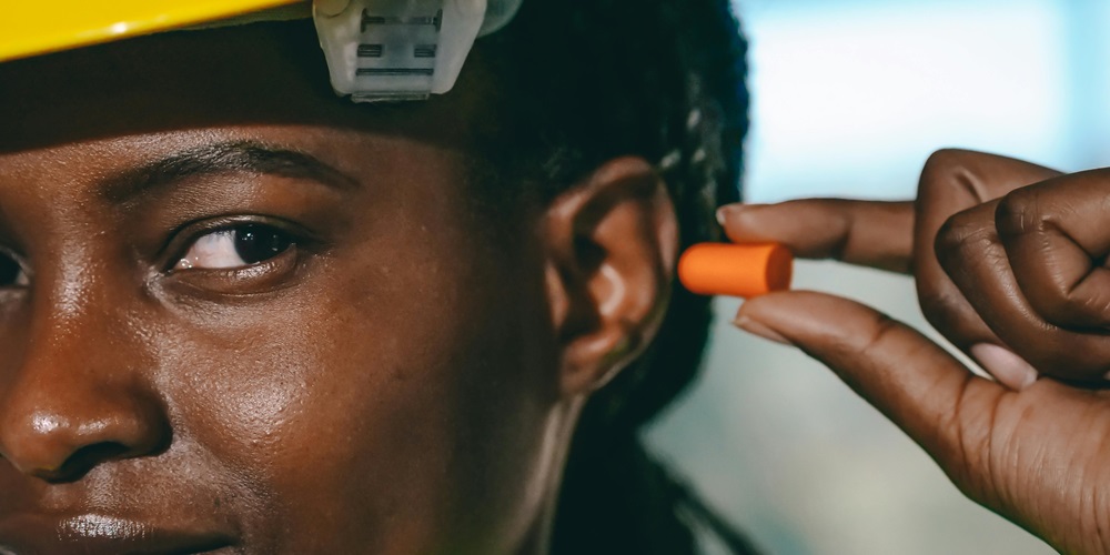 construction worker putting in ear plugs_Photo by kindel media