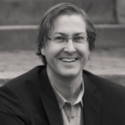A black-and-white photo of a man, Craig DiLouie, smiling. Image by Craig DiLouie.