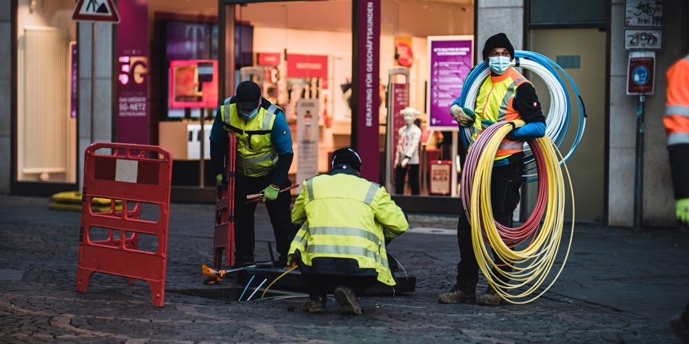 Technicians installing fiber optic cable. | Photo by Mika Baumeister on Unsplash
