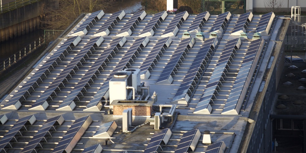 Solar panels laid out on a flat roof of a commercial building