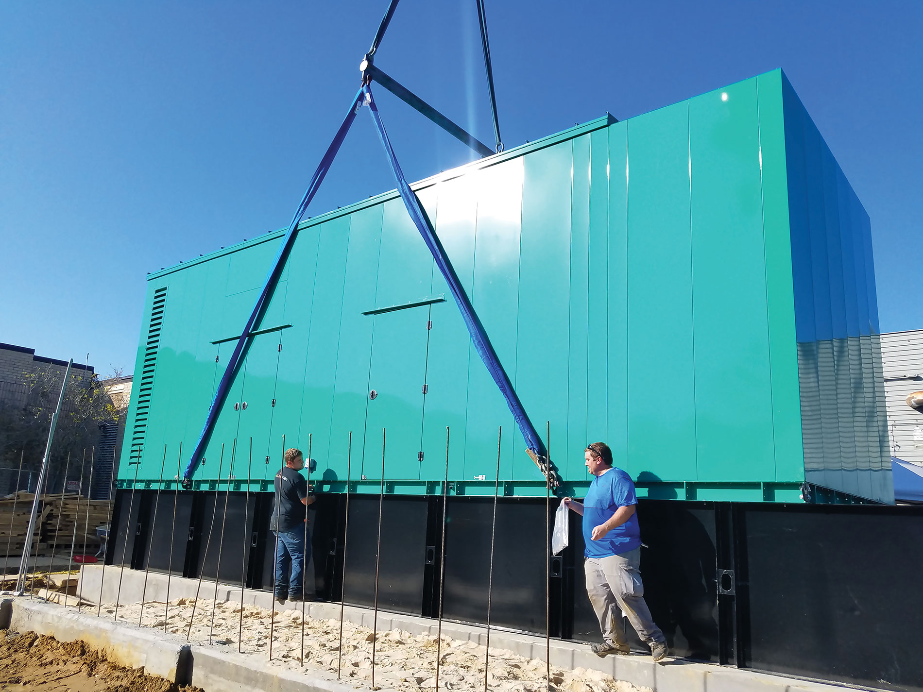 Crew members outside a storage unit with straps. Image by Buffalo Electric Inc.