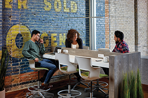 people sitting at table around a computer