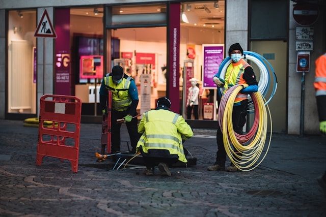 Fiber techs installing fiber optic cabling. Photo by Mika Baumeister on Unsplash