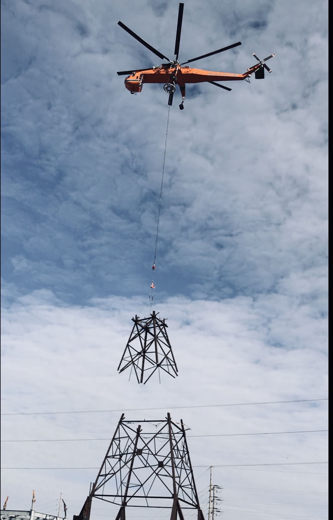 A helicopter lowers a piece of the Gateway to Roxford 345 kV Transmission Line