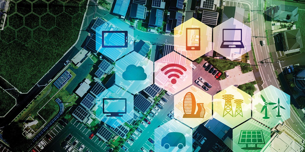 Illustration of hexagons with energy and electronic icons laid over an image of buildings, parking lots and fields. Image by Getty images / metamorworks.