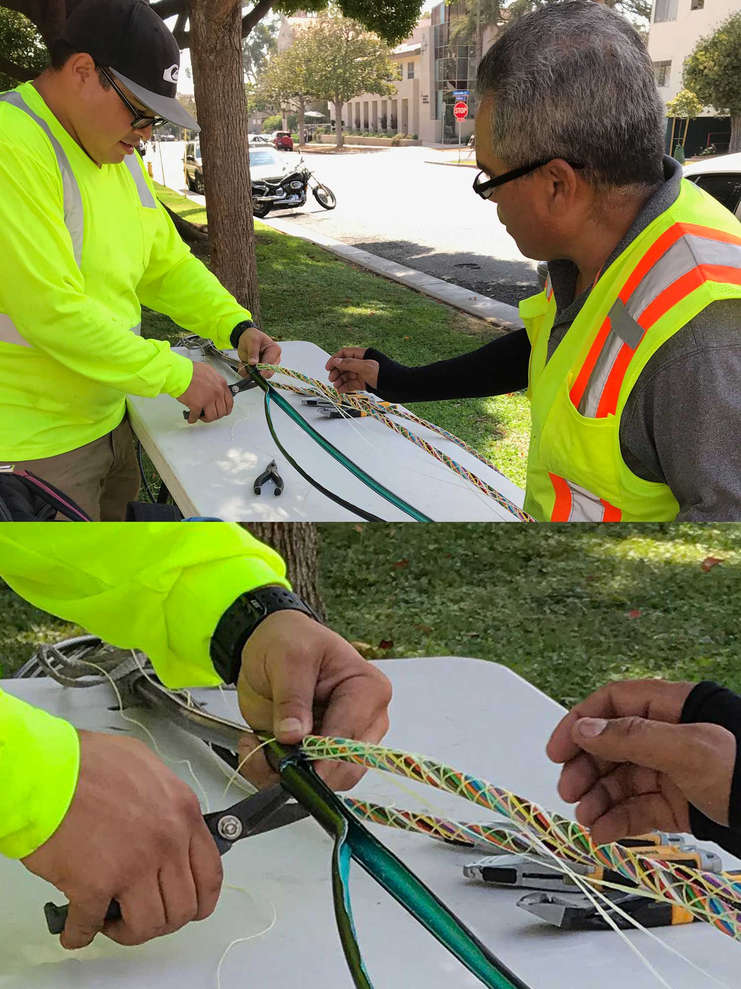 Two technicians preparing an armored outside plant cable for splicing, showing color-coded buffer tubes organized with binder tape for identification, in compliance with the TIA 598 standard.