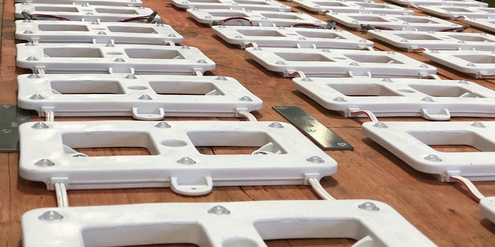 Rosendin team members prefab LED lights for installation in bathrooms.