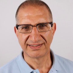 A man, Jim Romeo, smiles in front of a gray background.