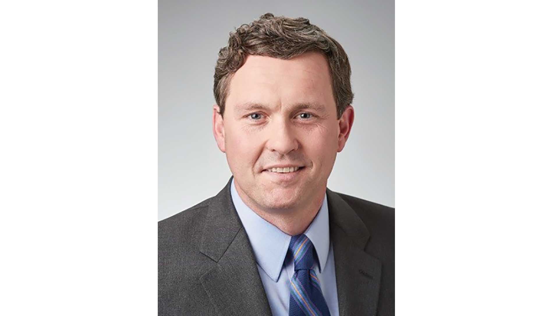 A photo of a man, Jeff Mayes, against a gray background.