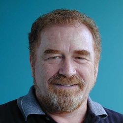 Mark-Ode-edited A man, Mark Ode, smiles in front of a blue background. Image by Mark Ode.