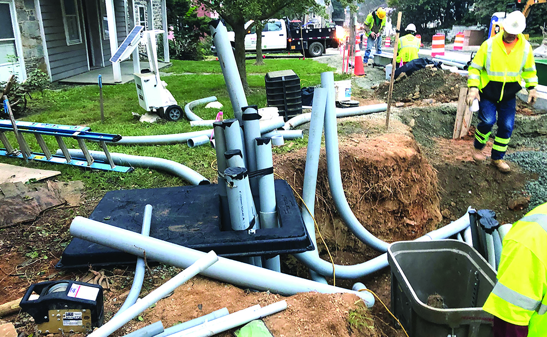 Pipes and workers in a ditch outside a home. Image by Town of Hillsboro.