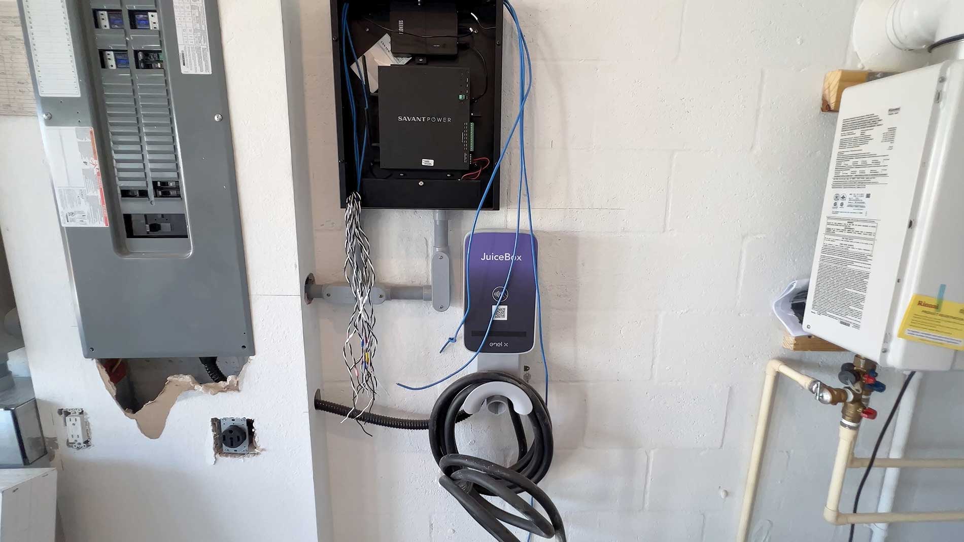 A smart panel and EV charger in a white garage. Image by Florida Power & Light Co. and Babcock Ranch.