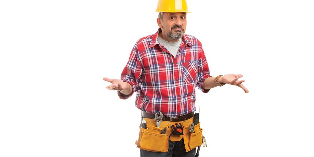 A man with a hard hat and tool belt shrugs. Image by Shutterstock / Thunderstock.
