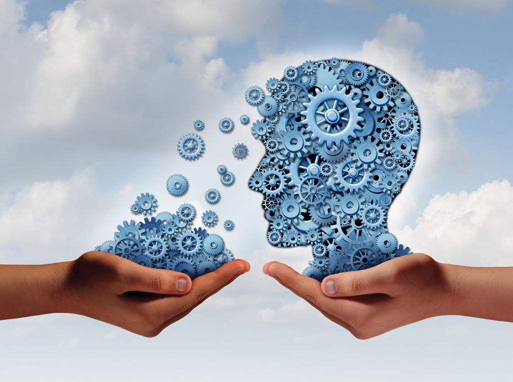shutterstock_195037466 Against a cloudy sky, one hand holds an illustration of a head made of cogs, and another hand holds cogs. Image by Shutterstock / Lightspring.