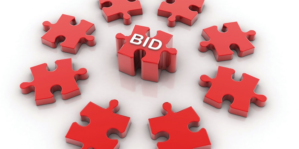 Illustration of red puzzle pieces in a circle around a red puzzle piece reading Bid. Image by Shutterstock / Ranjith Ravindran.