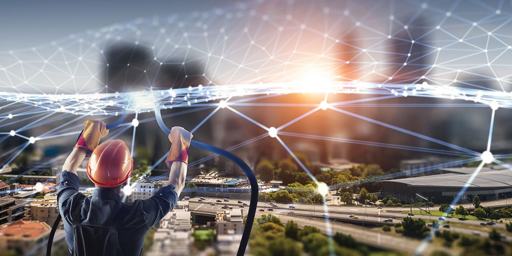 A worker connects a shimmering web over a city. Image by Shutterstock / Sergey Nivens.