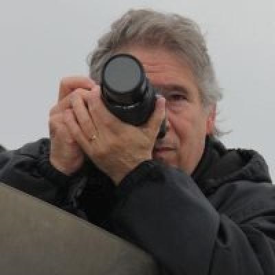 Stephen Carr_1 Stephen Carr headshot. A man with gray hair holding up a camera.