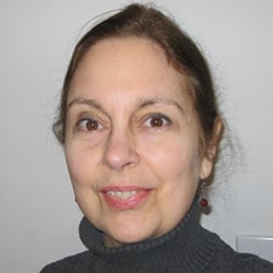 A woman, Susan DeGrane, smiles at the camera.