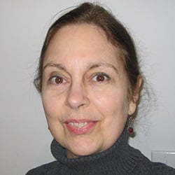 A woman, Susan DeGrane, smiles at the camera.