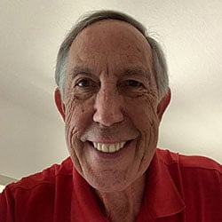A man, Tom Hammerberg, smiles in front of a tan background. Image by Tom Hammerberg.
