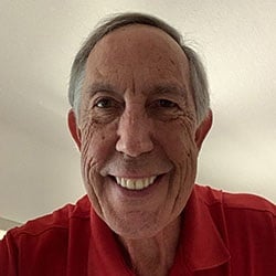 A man, Tom Hammerberg, smiles in front of a tan background. Image by Tom Hammerberg.