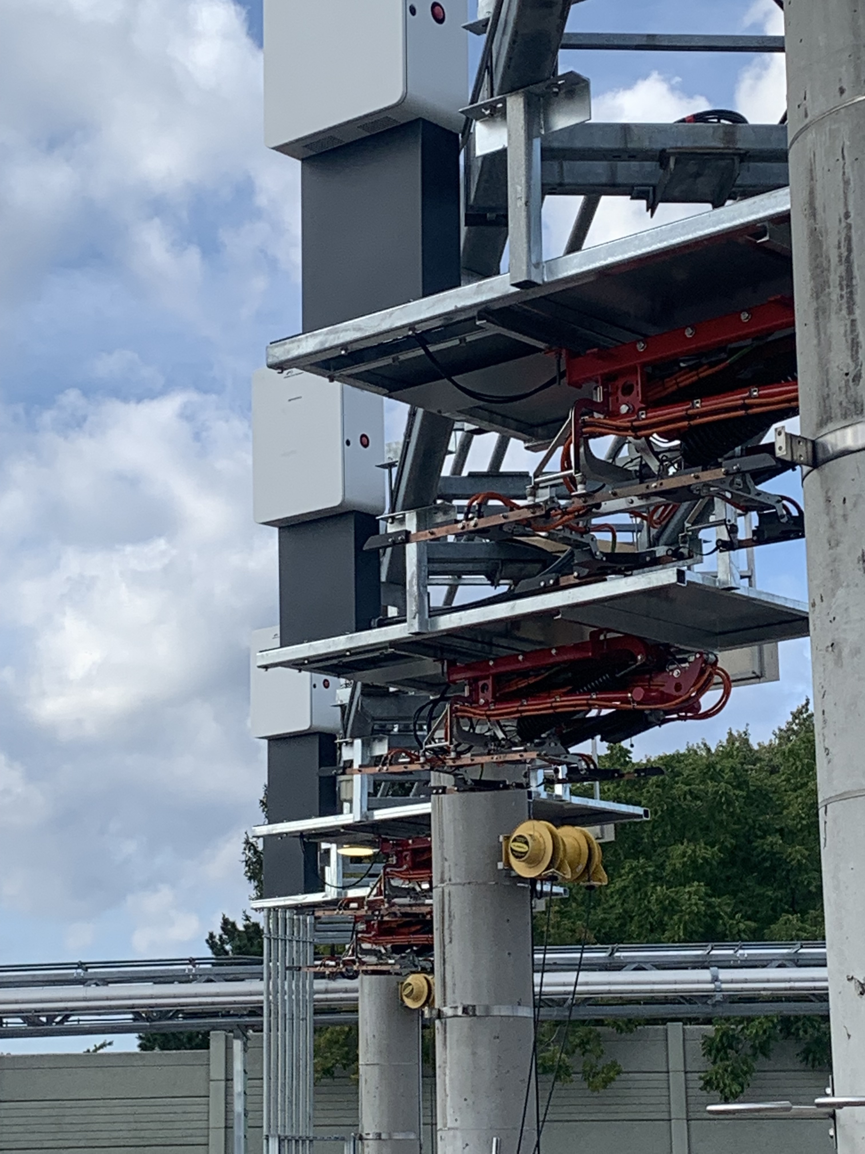 EV bus charging infrastructure against a blue sky.
