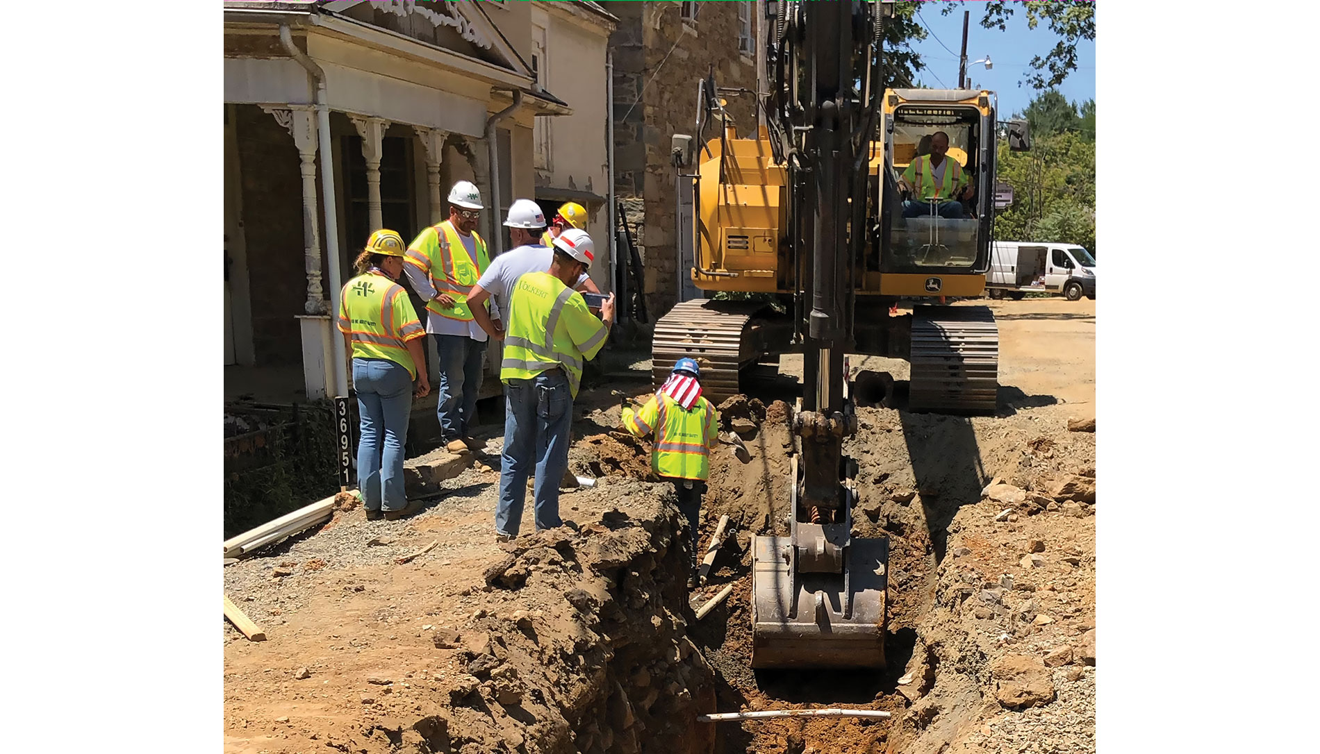 Excavator and several workers in dirt next to a building. Image by Town of Hillsboro.