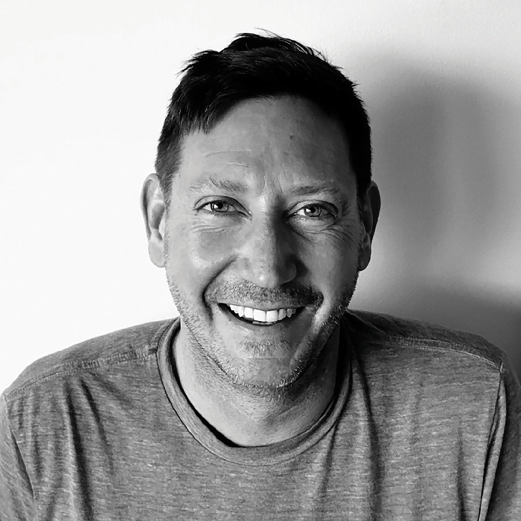 Grayscale photo of a man, Will Benentt, smiling. Image by Will Bennett.